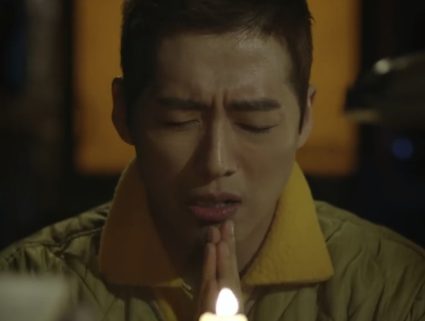 Nam Goong Min praying in a quilted jacket